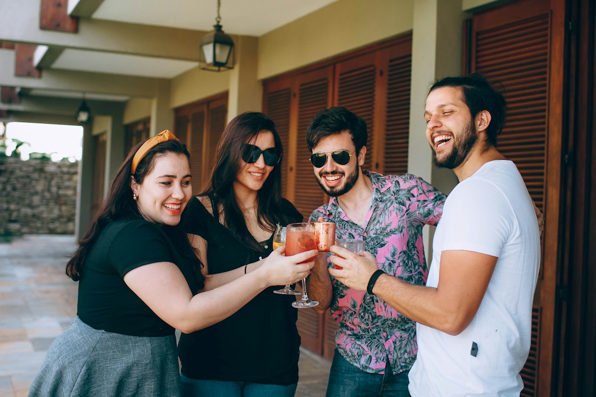 Grupo de amigos sonriendo mientras brindan con sus bebidas